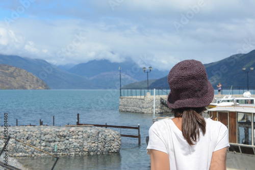 woman from behind looking at the lake and the mountain. in lake puelo, chubut province of patagonia argentina photo