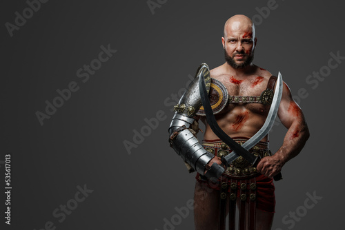 Portrait of powerful gladiator from past with naked torso and muscular build.