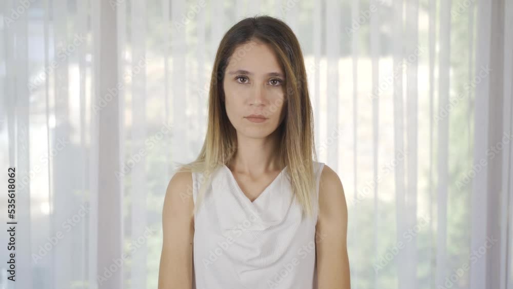 Young woman looking calmly at camera.
Woman looking at camera at home.
Young woman looking calmly at camera.
Woman looking at camera at home.