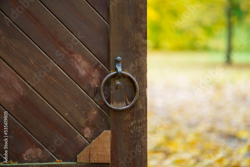 Fotografie Wooden gate with handle in the shape of a ring of metal