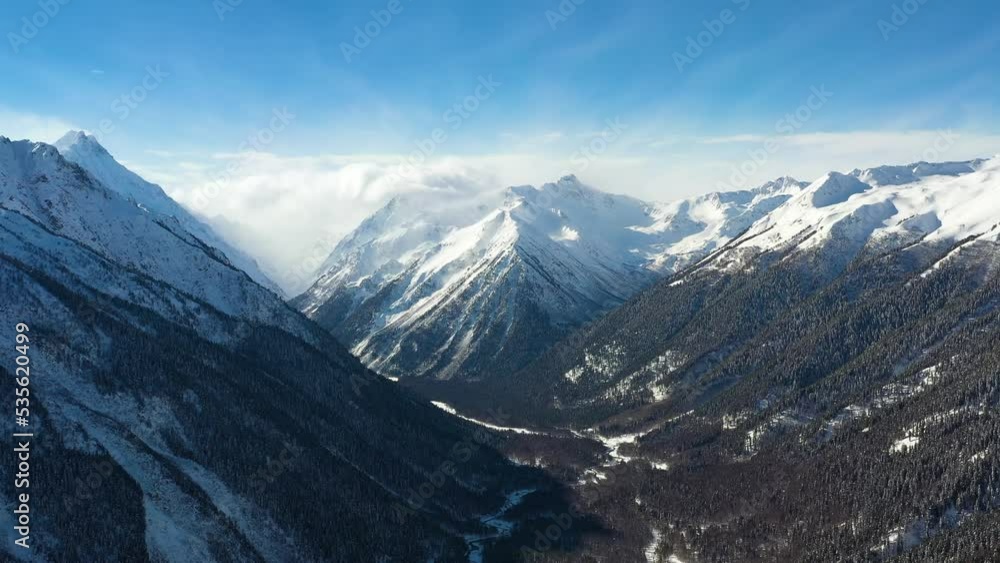 Air flight through mountain clouds over beautiful snow-capped peaks of mountains and glaciers. Air flight through mountain clouds over beautiful snow-capped peaks of mountains and glaciers.