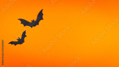 Orange cute Halloween background design with bats silhouettes and copy space