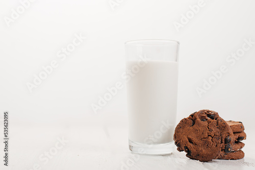 A glass of milk with biscuits on a white background