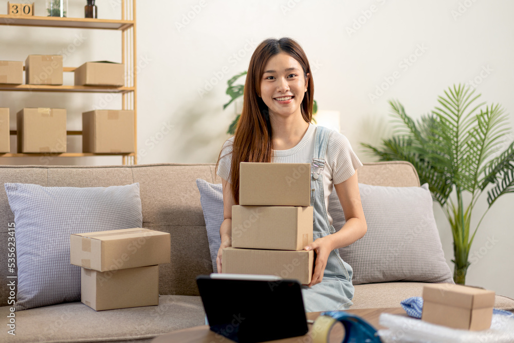 Young entrepreneur is holding cardboard boxes to prepare writing address and home delivery to customers Young entrepreneur is holding cardboard boxes to prepare writing address and home delivery to customers