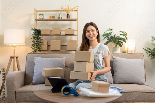 Young entrepreneur is holding cardboard boxes to prepare writing address and home delivery to customers