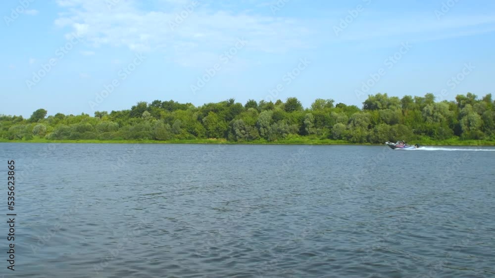 A calm, wide river with a forest on the far bank. A calm, wide river with a forest on the far bank.