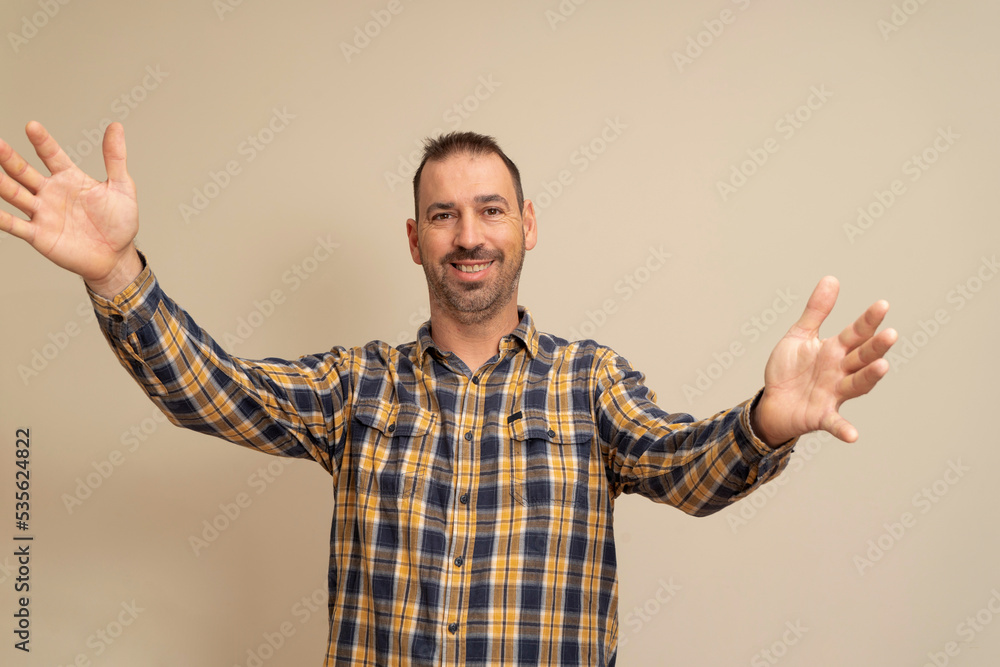 Free hugs for the person who had a bad day. Cheerful friendly male model in plaid shirt throwing hands towards camera, wanting to hug, smiling broadly, welcoming friend to come into his arms. Free hugs for the person who had a bad day. Cheerful friendly male model in plaid shirt throwing hands towards camera, wanting to hug, smiling broadly, welcoming friend to come into his arms.