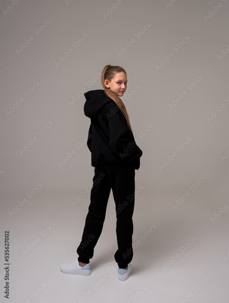 girl with long hair in a black tracksuit girl with long hair in a black tracksuit