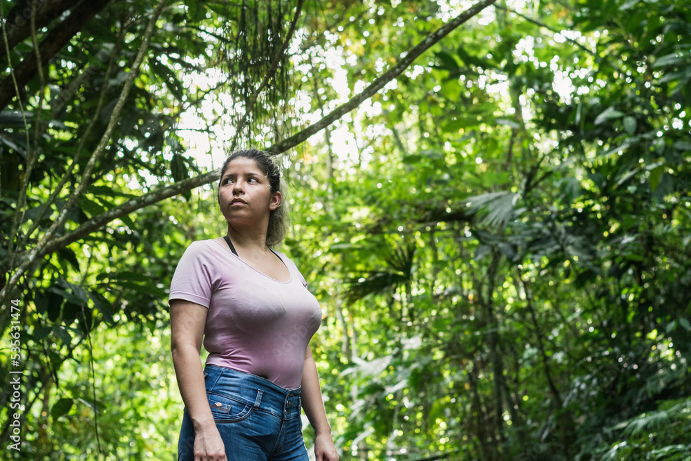 beautiful latin girl exploring in the middle of a colombian jungle. woman looking curiously while walking through the beautiful nature of the south american jungles. beautiful latin girl exploring in the middle of a colombian jungle. woman looking curiously while walking through the beautiful nature of the south american jungles.