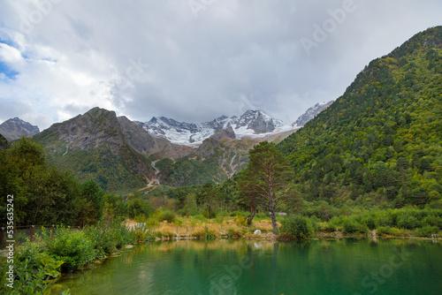 Mountain landscape with a glacier in the distance. Lake in the mountains. Tana glacier in Ossetia