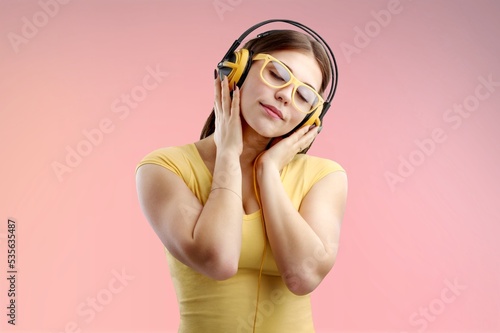 Happy woman with phone listen music in modern headphones