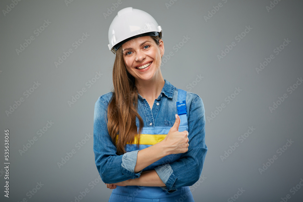 Smiling woman builder or engineer in safety helmet showing thumb up. Isolated female portrait. Smiling woman builder or engineer in safety helmet showing thumb up. Isolated female portrait.
