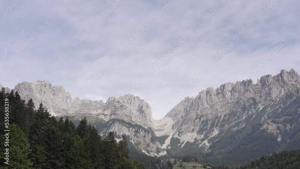 Slow tracking drone shot of the famous Ellmauer Tor in the middle of the Kaisergebirge in the Austrian state of Tyrol. Low angle shot of lush green vegetation along the mountain slope in Austria, Euro Slow tracking drone shot of the famous Ellmauer Tor in the middle of the Kaisergebirge in the Austrian state of Tyrol. Low angle shot of lush green vegetation along the mountain slope in Austria, Euro