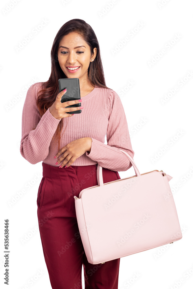 Cheerful Indian young woman using smart phone with hand bag. Cheerful Indian young woman using smart phone with hand bag.