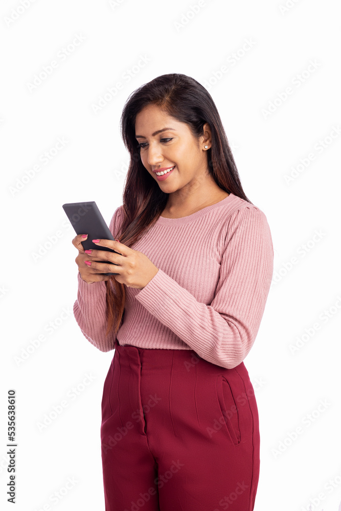Cheerful Indian young woman using smart phone. Cheerful Indian young woman using smart phone.