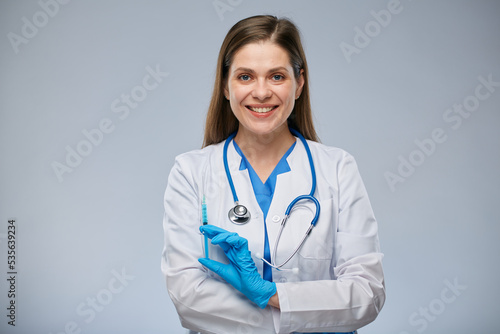 Smiling doctor holding syringe with vaccine. Isolated female medical worker portrait.