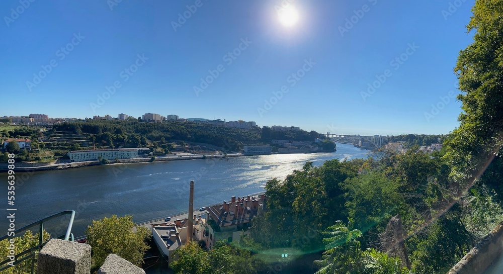Fototapeta premium Wide Douro river with some boats sailing in a beautiful skyline from the city Porto, in Portugal