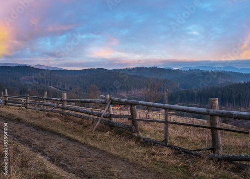 Picturesque pre sunrise morning above late autumn mountain countryside. Ukraine, Carpathian Mountains, Petros top in far. Peaceful traveling, seasonal, nature and countryside beauty concept scene.