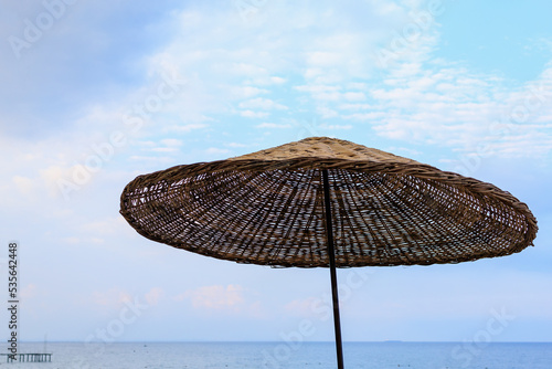 Wooden natural umbrella for relaxing in the shade of tourists on the beach. Background with copy space