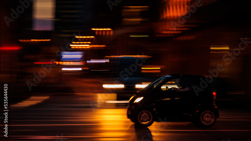City Life in Frankfurt am Main in Germany, Europe. Night image in the streets of driving cars. Lovely blurry orange neon lights. Dark Cars and futuristic background