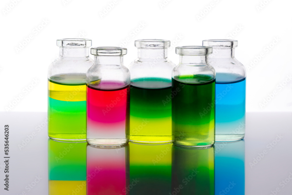 Colored water layers in small glass bottles isolated on white background Colored water layers in small glass bottles isolated on white background
