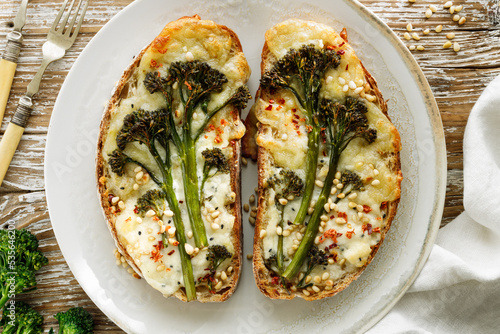 Grilled sandwiches, toasts with baby broccoli, cheese and pine nuts on a plate, top view