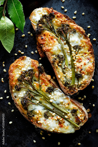 Grilled  sandwiches with baby broccoli, cheese and pine nuts on a black background, top view