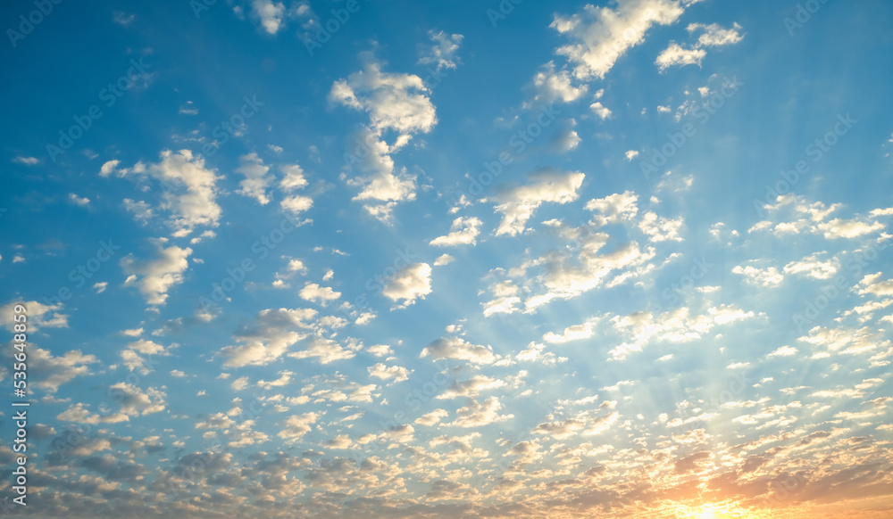 Blue sky with twilight clouds. The sun is setting over the horizon. Yellow dawn. Red sunset. Pink clouds. Blue sky with twilight clouds. The sun is setting over the horizon. Yellow dawn. Red sunset. Pink clouds.