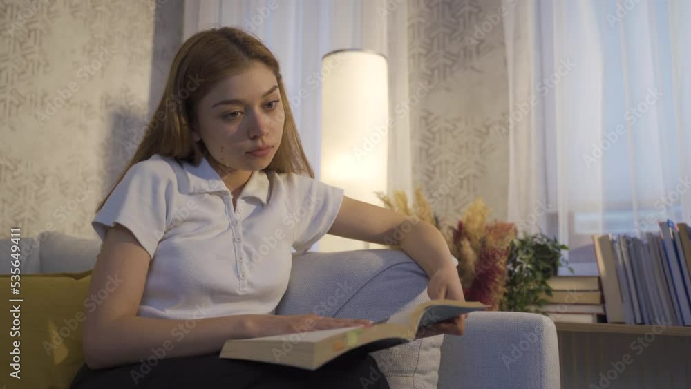 Young woman reading a book.
Young girl reading a book at home, focused on the book.
Young woman reading a book.
Young girl reading a book at home, focused on the book.