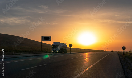 View of trucks carrying loads at sunrise © mehmetcan