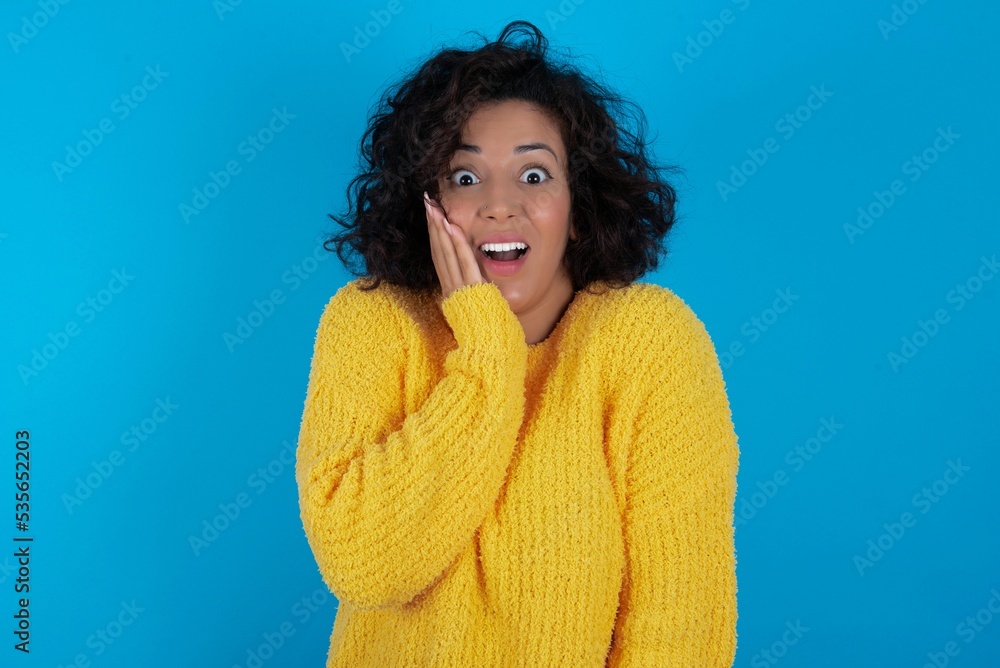 Foto de Shocked, astonished young beautiful woman with curly short hair ...