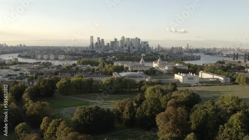 Trees and building aerial push in with London city skyline in background. Greenwich drone