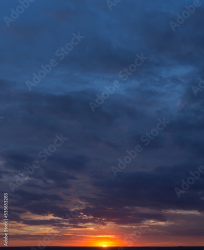 Landscape with bloody sunset. Panorama. Tragic gloomy sky. The last flashes of the sun on the storm clouds.