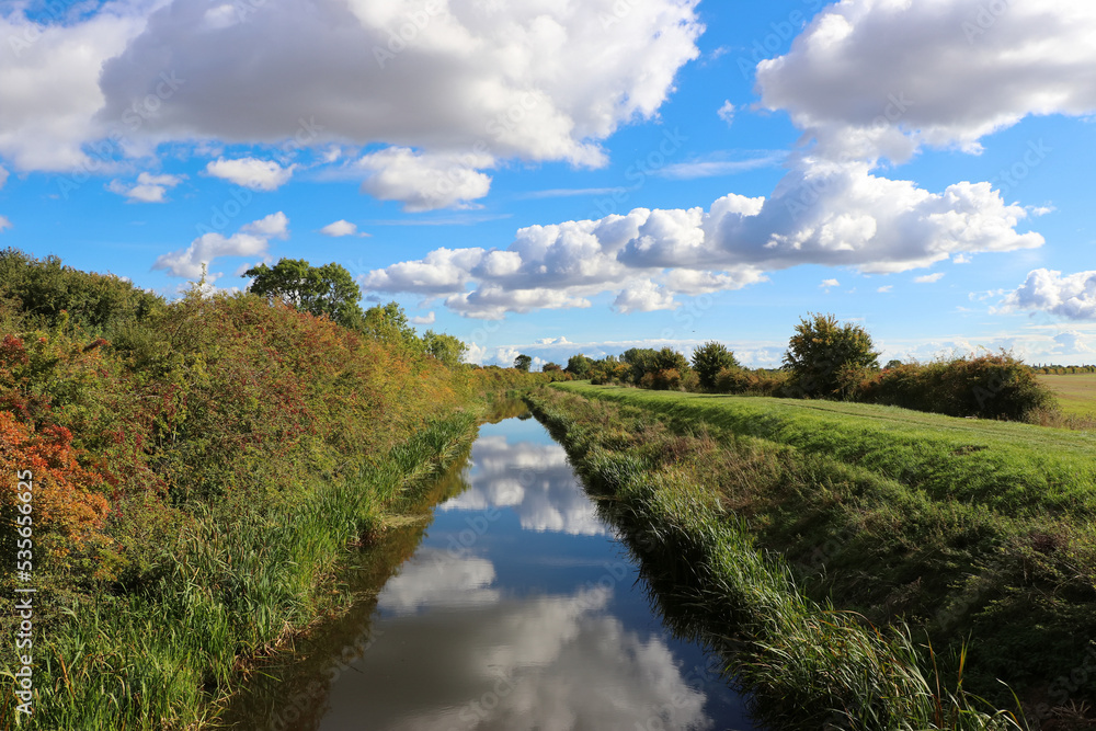 landscape with river and blue sky, cloud reflection in the water, early autumn in the countryside