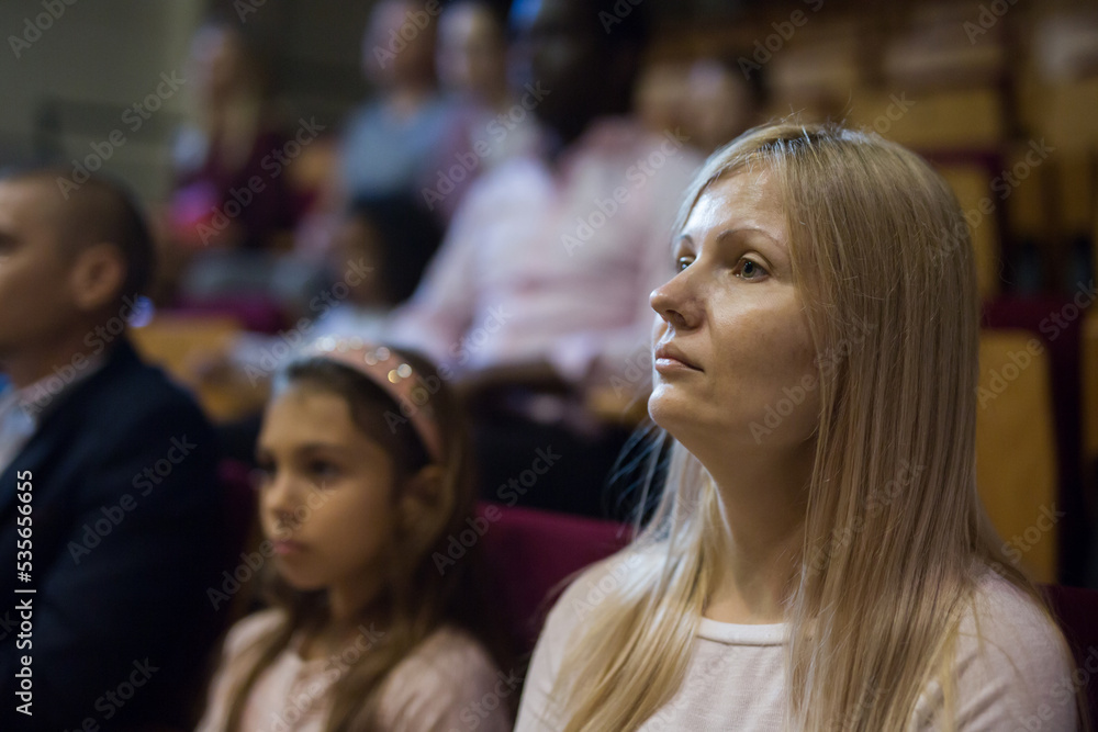 Obraz premium close up of european woman sitting at film in cinema auditorium .
