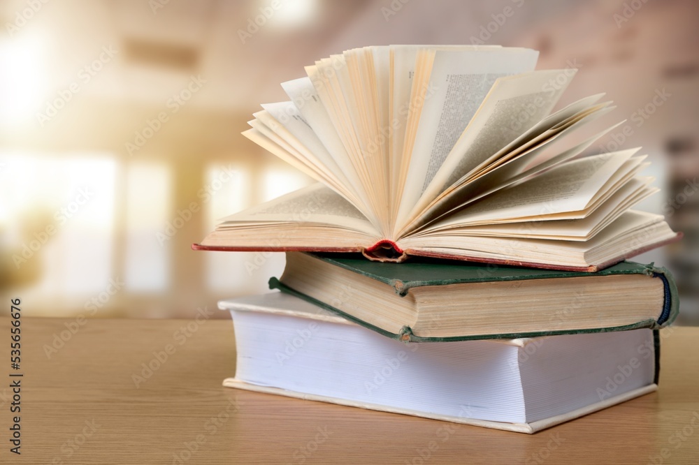 Reading book stack on wooden desk Reading book stack on wooden desk