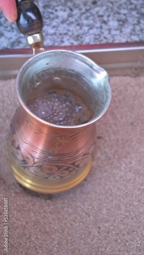 Vertical video of preparation of Turkish coffee in sand. Turkish coffee concept photo