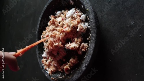 The process of making urap seasoning. Made from grated coconut mixed with chili sauce and onions photo