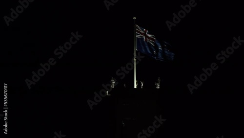 NZ flag fluttering in the night sky. photo