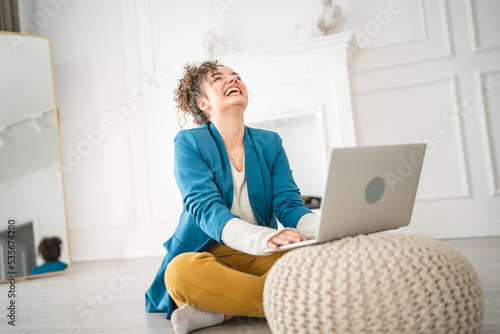 one woman young adult use computer while sitting on the floor at home