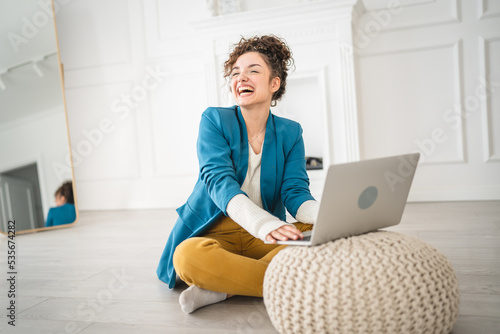 one woman young adult use computer while sitting on the floor at home