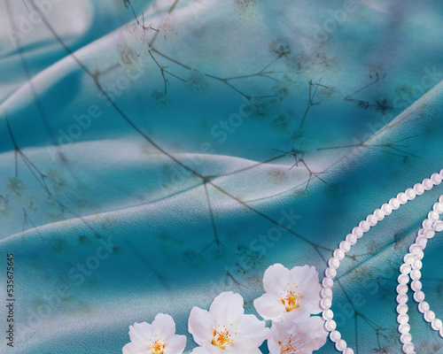 Blue silk background with flower and pearl