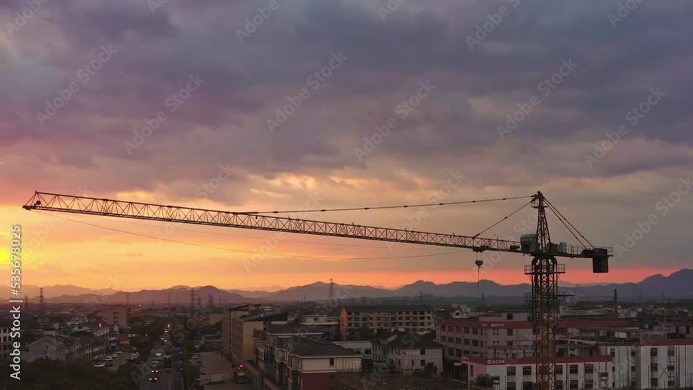 aerial view of busy cranes in construction site at sunset aerial view of busy cranes in construction site at sunset