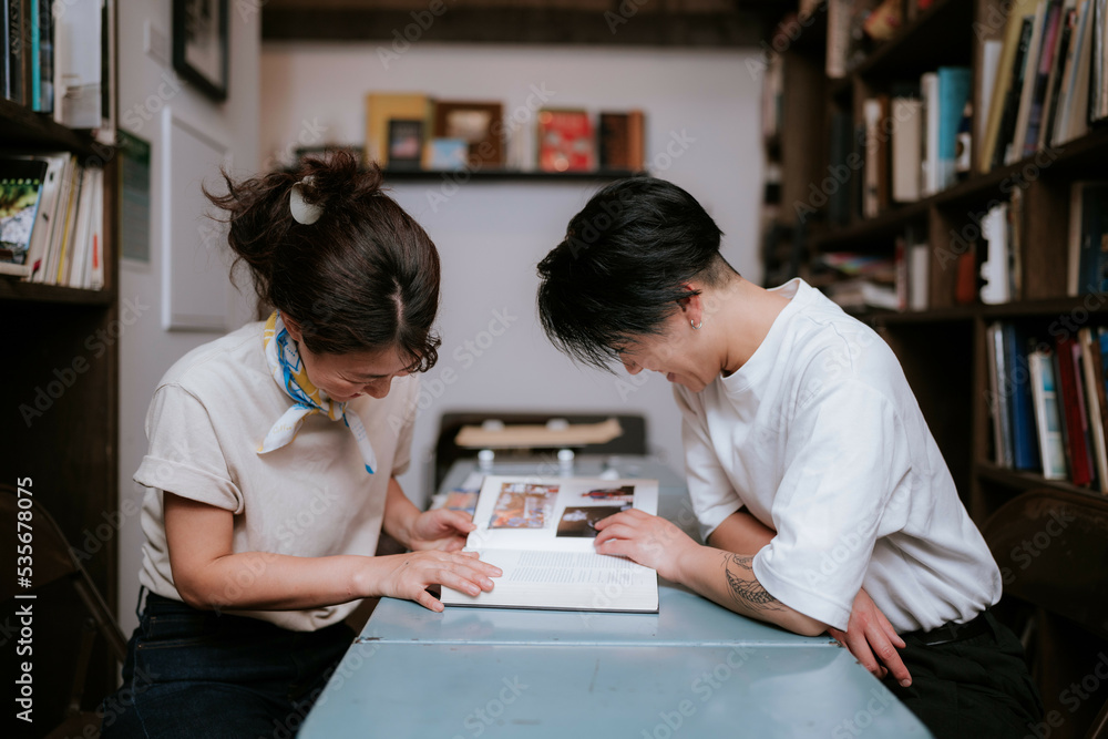 机に本を広げて読む二人の女性 机に本を広げて読む二人の女性
