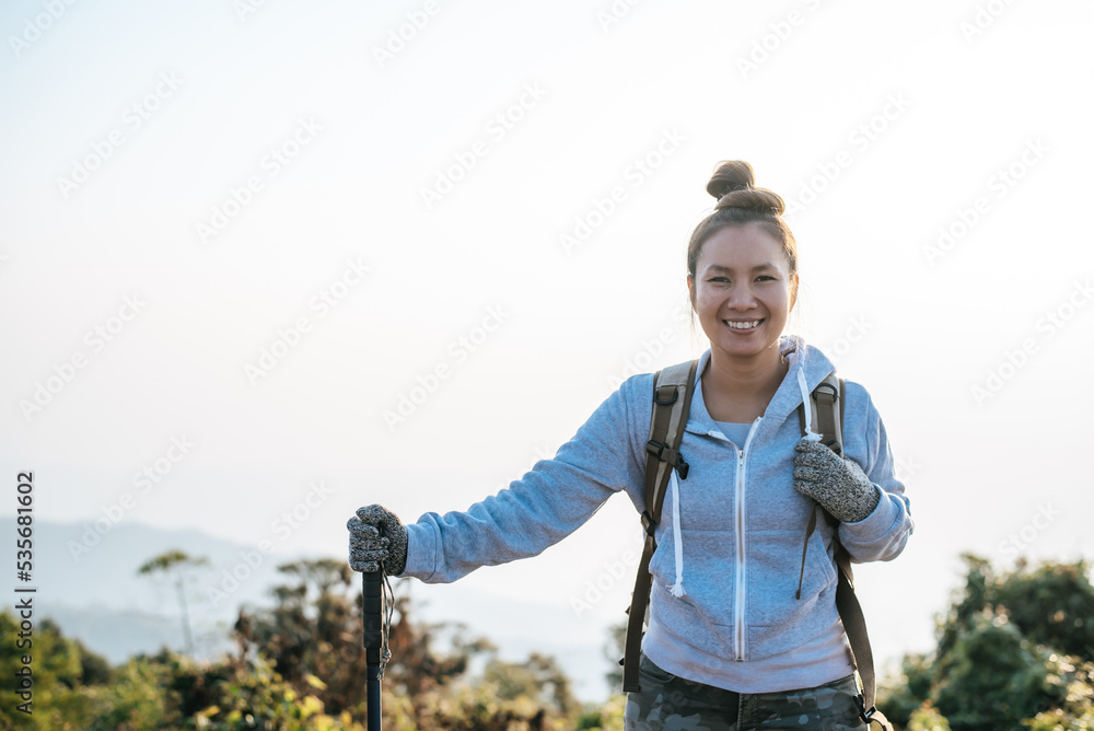 Portrait of Happy Asian hiker woman with backpack looking at camera on mountain with copy space Portrait of Happy Asian hiker woman with backpack looking at camera on mountain with copy space