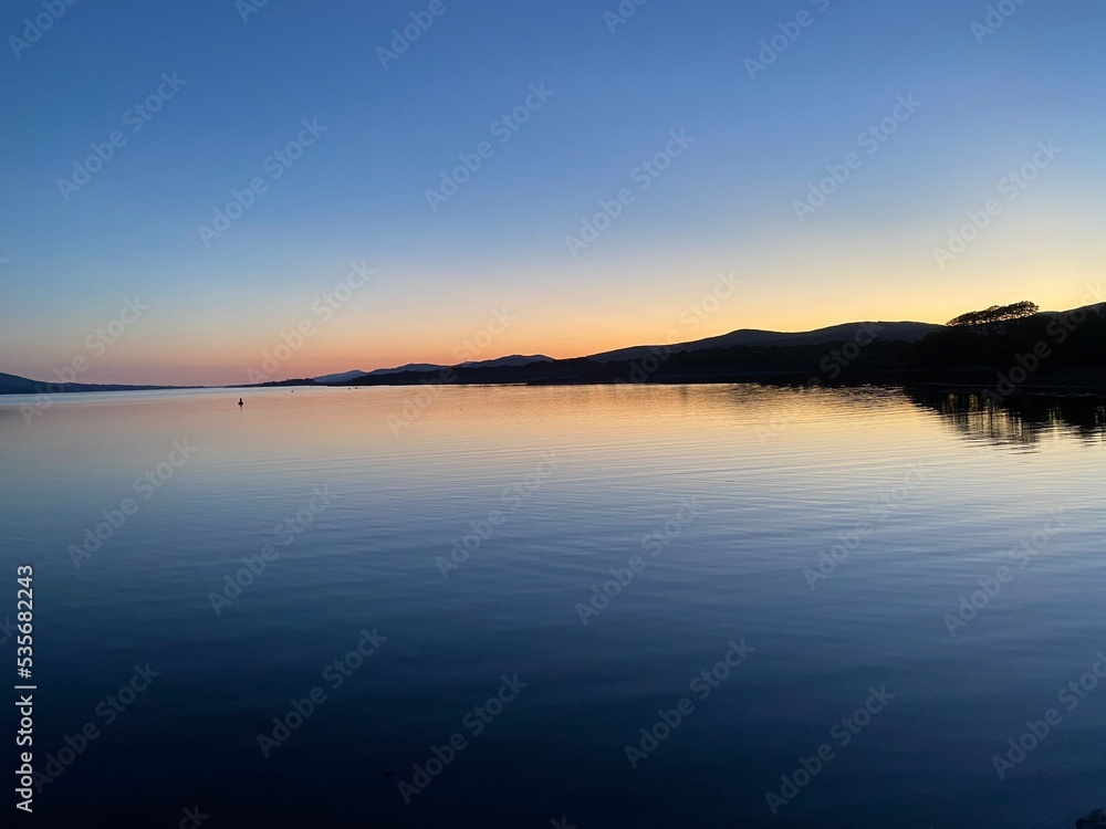 Kenmare bay at sunset viewed from Kenmare pier, Kerry, Ireland. Kenmare bay at sunset viewed from Kenmare pier, Kerry, Ireland.