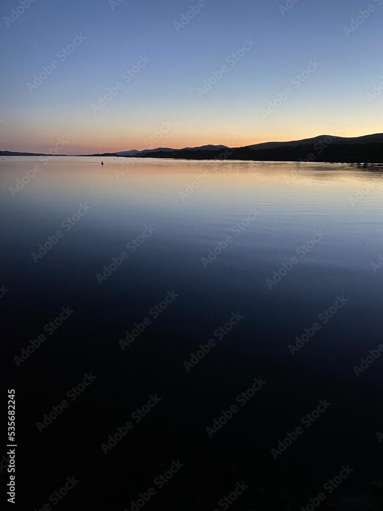 Kenmare bay at sunset viewed from Kenmare pier, Kerry, Ireland. Kenmare bay at sunset viewed from Kenmare pier, Kerry, Ireland.