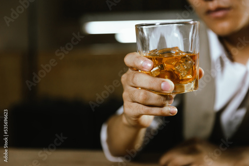 The bartender serves whiskey to customers at a bar or restaurant.