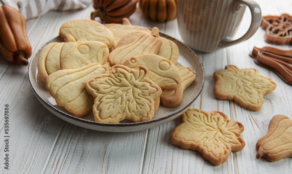 Cookies shaped like pumpkin and leaves on rustic wood background Cookies shaped like pumpkin and leaves on rustic wood background