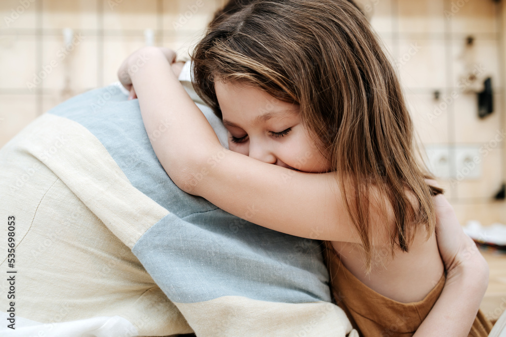 Sweet little girl hugging her parent. Blurred background Sweet little girl hugging her parent. Blurred background